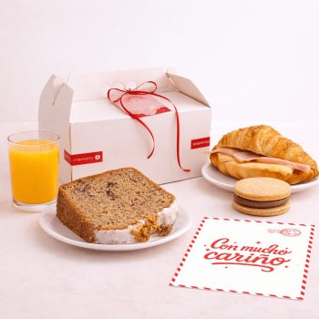 Sorpresa de agradecimiento con croissant, budín, alfajor, jugo y tarjeta en caja blanca con moño rojo